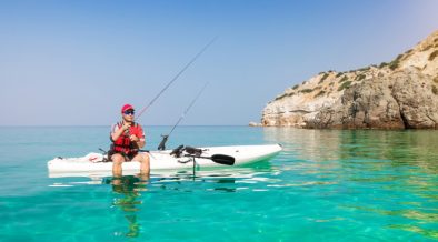 Angler mit eigener Fischfangmethode auf Kajak in türkisem Wasser - Angelmethoden in Kroatien
