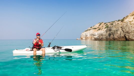 Angler mit eigener Fischfangmethode auf Kajak in türkisem Wasser - Angelmethoden in Kroatien