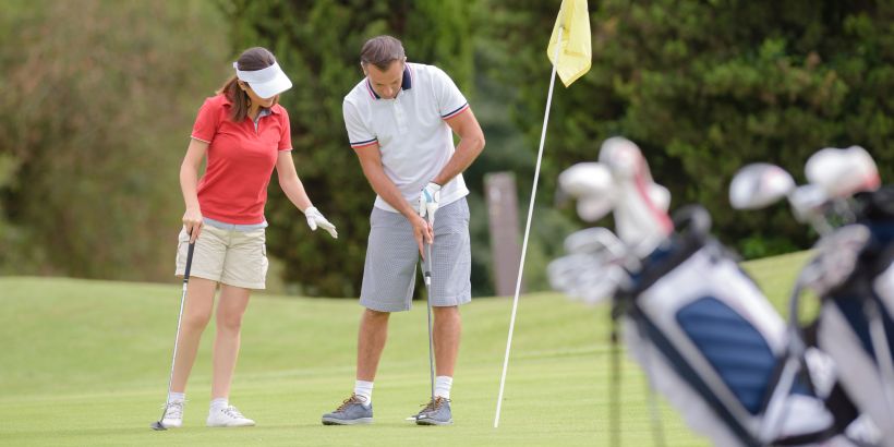Golfspieler beim Einhalten der Golf Etikette auf dem Green - Verhalten auf dem Golfplatz