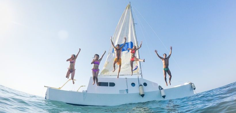 Urlauber haben Spaß beim Sprung vom Boot ins Meer - Regln, Tipps & Infos für unbeschwerte Bootstouren