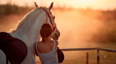 Mädchen nach dem Reiten in Dalmatien mit ihrem Pferd bei Sonnenuntergang