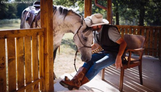 Ranchbesitzer Tomislav Marčenić auf seiner Veranda mit Pferd auf der Ranch Chivas