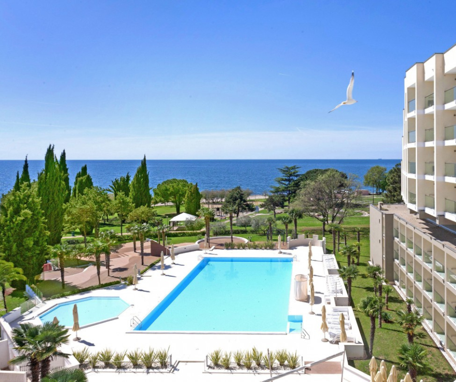 Hotel Materada in Poreč – Blick über Pool, Garten und die Adria, mit Möwe im Flug und mediterranem Park direkt am Meer.