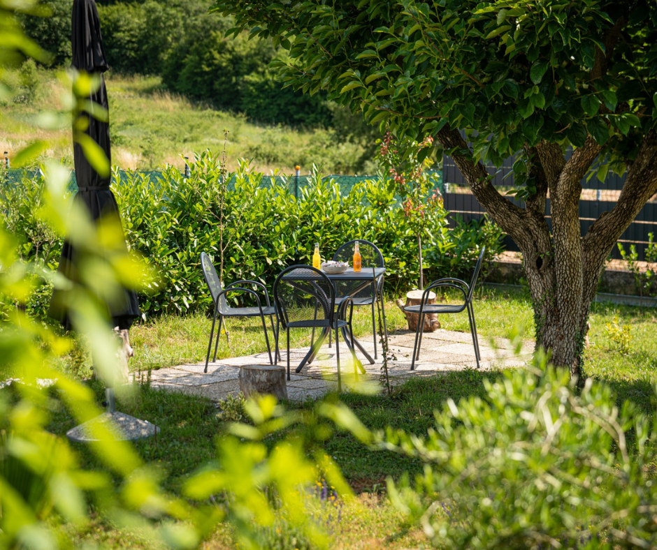 Gartensitzplatz unter Bäumen bei den Appartements Carpe Diem nahe Poreč, Istrien