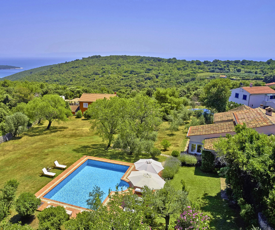 Kinderfreundliche Ferienhäuser: Villa Arbora mit großem Garten, Pool und Blick auf die grüne Landschaft und das Meer in der Ferne.