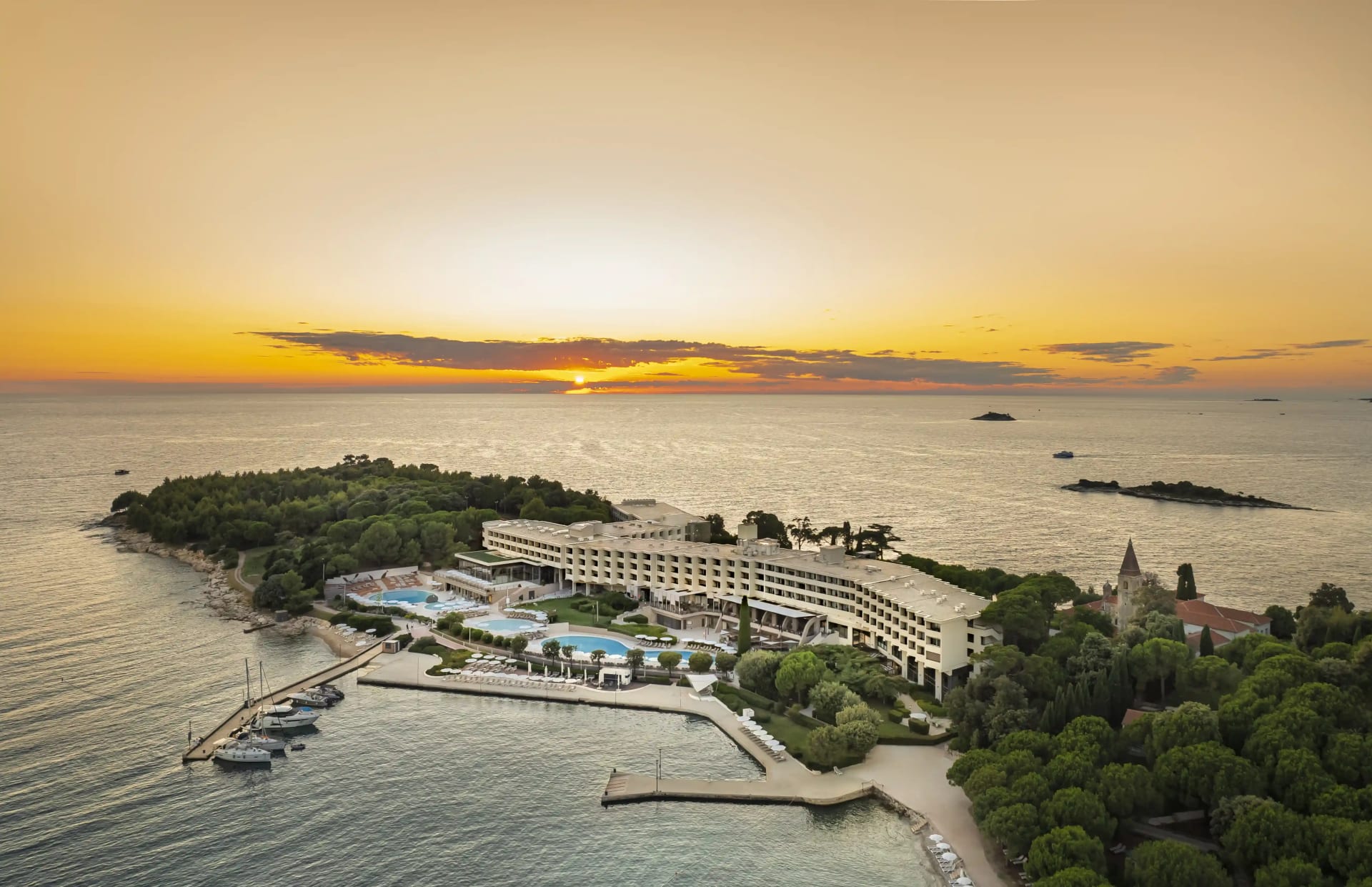 Island Hotel Istra auf der Insel Sveta Andrija bei Sonnenuntergang – luxuriöses Inselresort in Rovinj, ideal für Frühbucher Kroatien 2026.