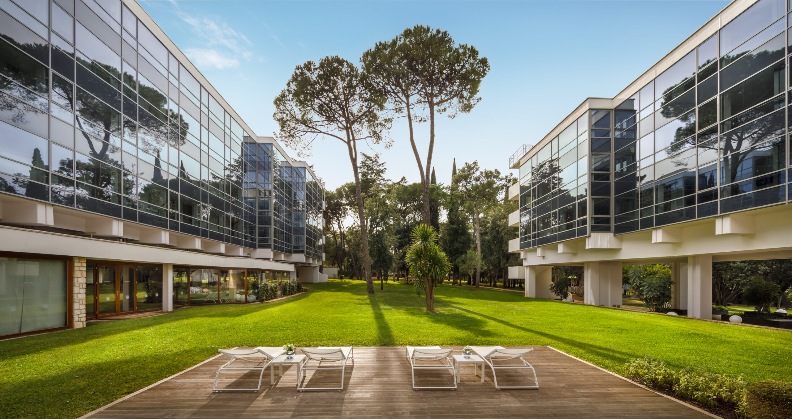Hotel Eden Rovinj – traumhafte Lage am Meer mit Blick auf die Lone-Bucht, ideal für Frühbucher Kroatien 2026. Sonnenliegen am Strand vor dem eleganten Hotel der Maistra Collection