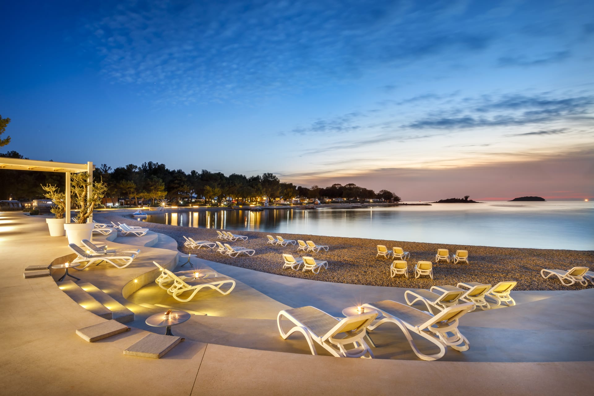 Valkanela Camping Resort bei Vrsar mit beleuchtetem Strand und Liegen bei Sonnenuntergang – perfektes Reiseziel für Frühbucher Kroatien 2026.